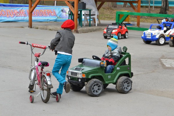 Дети катаются на машинках и велосипедах в парке  © Алёна Груя