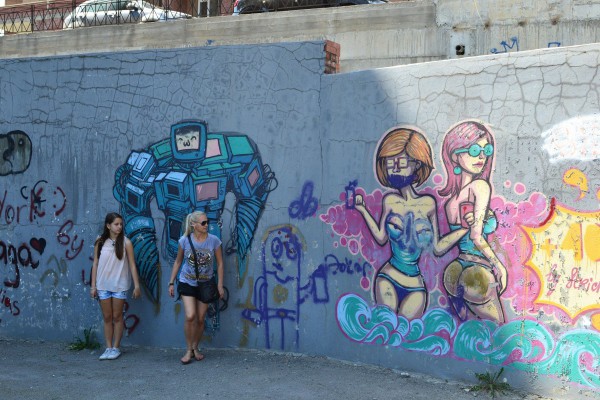 Экскурсанты фотографируются на фоне граффити © Алёна Груя